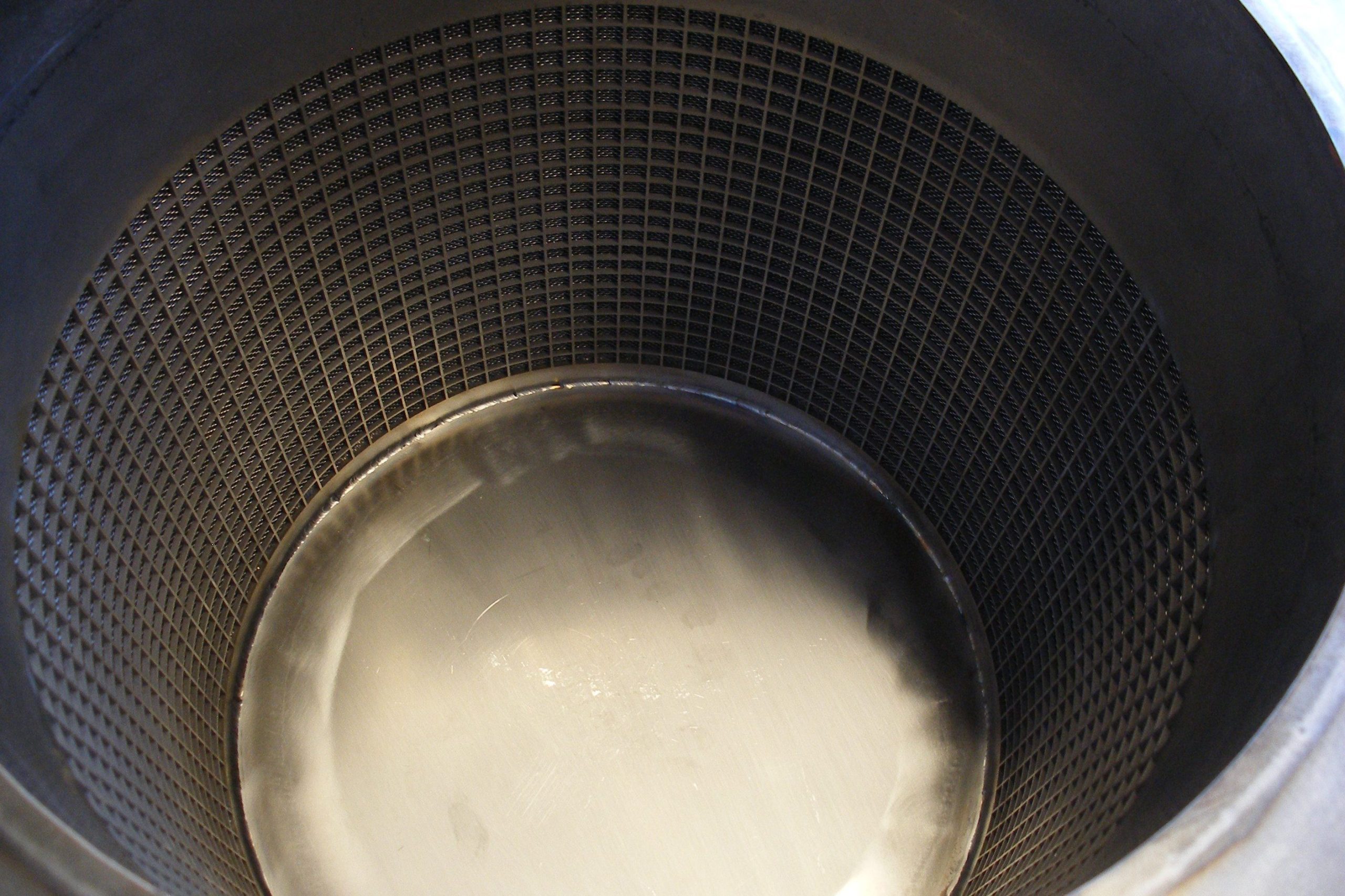 A close-up of a metal perforated strainer.