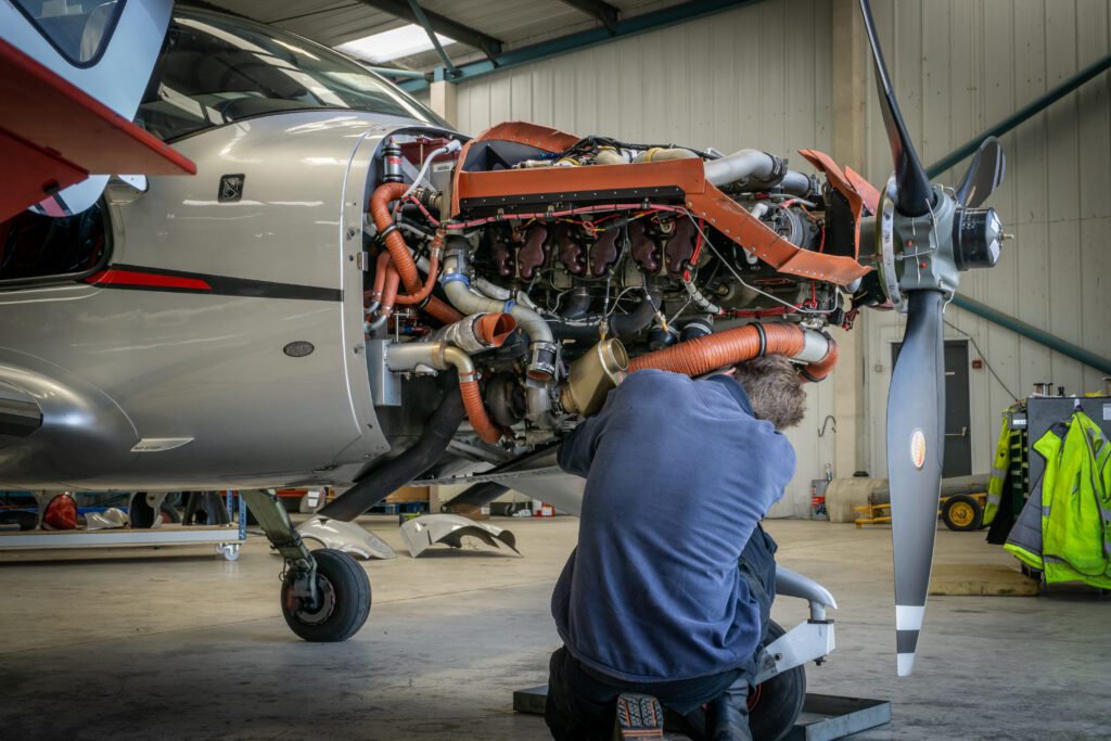 A mechanic works on the engine of a small plane.